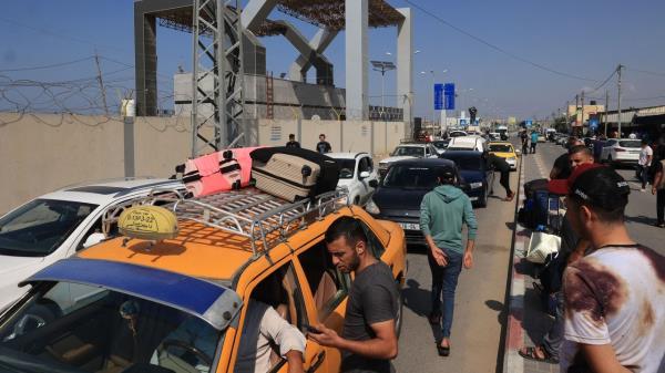 Palestinians with foreign passports arrive at the Rafah gate hoping to cross into Egypt as Israel's attacks on the Gaza Strip co<em></em>ntinues on October 14.. 