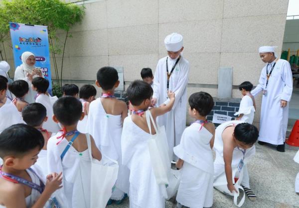 Children during the practice version of performing the jamrah wher<em></em>e they threw pebbles at a wall during a practice version of the “sto<em></em>ning of the devil” during the 